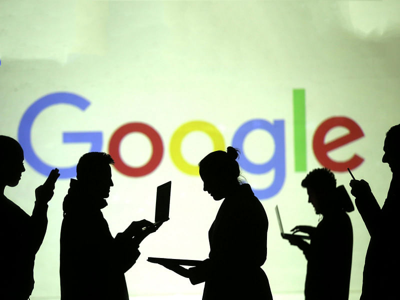 Silhouettes of mobile users are seen next to a screen projection of Google logo in this picture illustration taken on 28 March 2018. Reuters