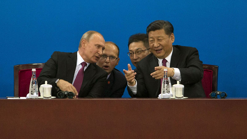 Russian president Vladimir Putin (L) and Chinese president Xi Jinping speak during a friendly match between Chinese and Russian youth Ice Hockey teams in northern China’s Tianjin municipality on 8 June