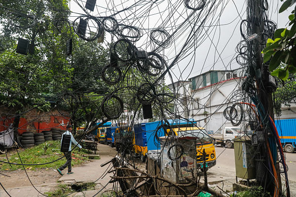 A 10 July 2020 photo shows jungle of twisted cables hanging from an electric pole by Shahid Tazuddin Ahmed Sarani in Dhaka, increasing risk of accidents