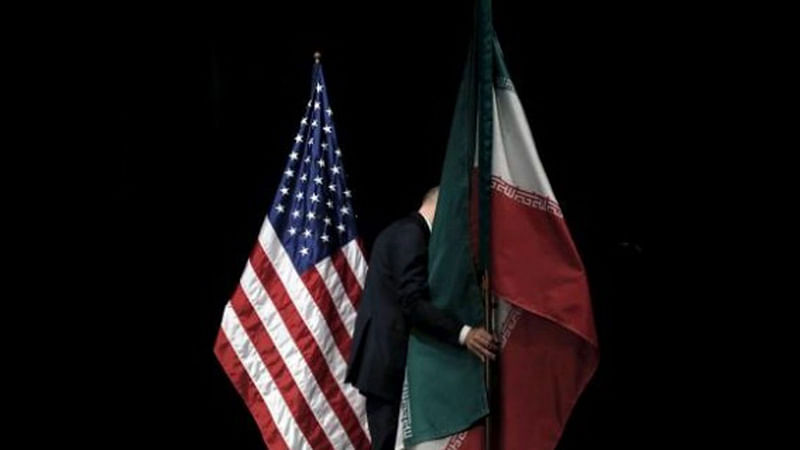 A staff member removes the Iranian flag from the stage after a group picture with foreign ministers and representatives of the US, Iran, China, Russia, Britain, Germany, France and the European Union during the Iran nuclear talks at the Vienna International Center in Vienna, Austria on 14 July, 2015.