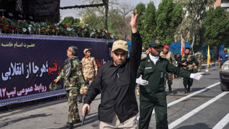 his picture taken on 22 September 2018 in the southwestern Iranian city of Ahvaz shows a soldier gesturing at the scene of an attack on a military parade that was marking the anniversary of the outbreak of its devastating 1980-1988 war with Saddam Hussein`s Iraq. Dozens of people were killed with dozens others wounded in an attack in the southwestern Khuzestan province on 22 September targeting on an army parade commemorating the anniversary of the 1980-1988 Iran Iraq war, state media reported