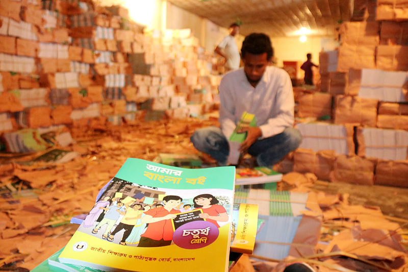 A man sorts textbooks at Ichhamati primary government school in Radhanagar in Pabna