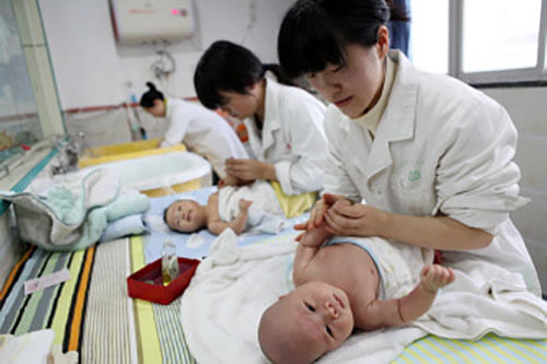 This file picture taken on 15 December 2016, shows nurses massaging babies at an infant care centre in Yongquan, Chongqing municipality, in southwest China.