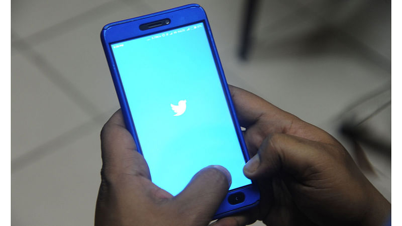 In this file photo taken on 27 March 2018 an Indian man poses with a smartphone showing the Twitter app in Siliguri