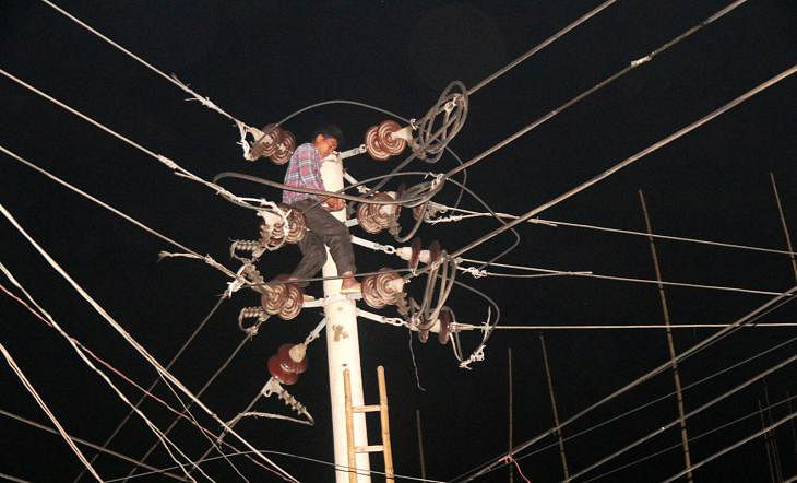 An employee of BPDC risks his life for fixing a cable on Abdul Hamid Road in Pabna on 30 March, 2019.