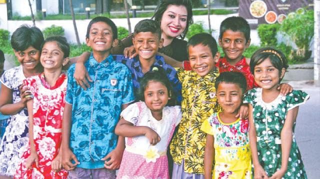 Children smile and pose after receiving new clothes for Eid