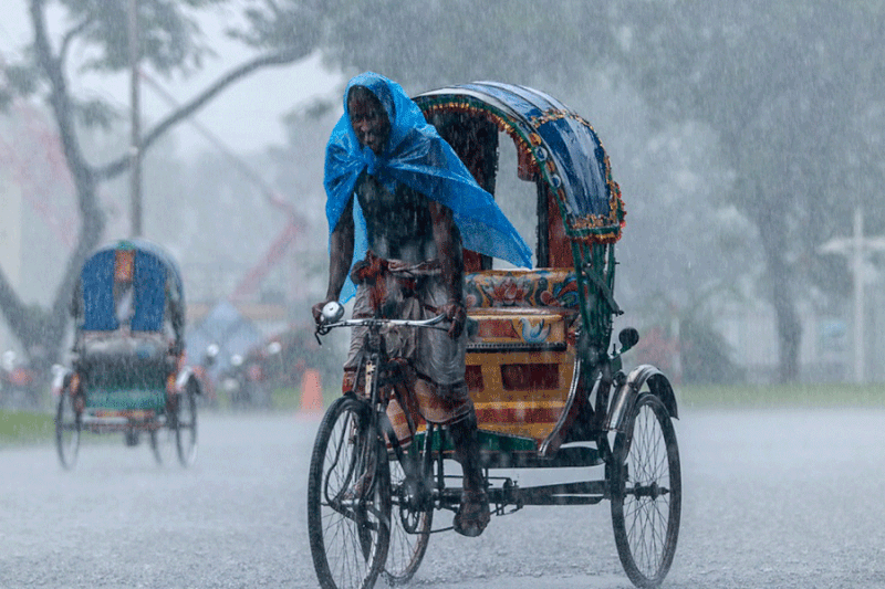 This picture shows a man pulling his rickshaw amidst heavy rain in Dhaka