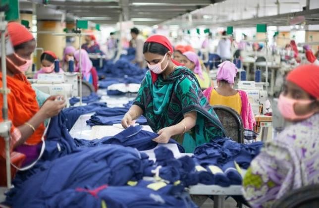 Workers work inside a garment factory