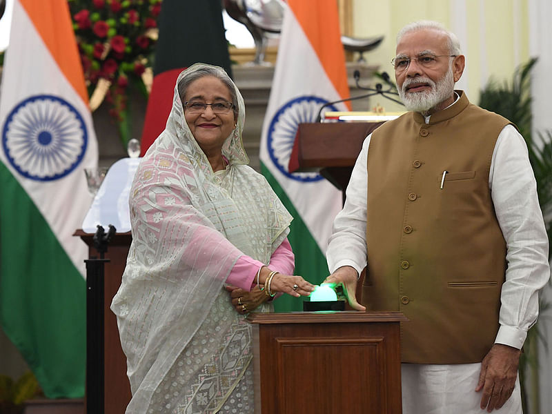 Bangladesh`s Prime Minister Sheikh Hasina and India`s Prime Minister Narendra Modi (R) press a button to remotely unveil plaques for three bilateral projects after a meeting in New Delhi on 5 October 2019.