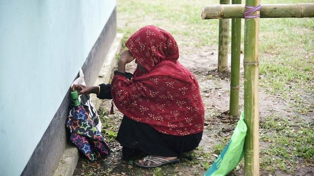 A woman waits to check her name on the draft list of the National Register of Citizens (NRC), as she sits outside an NRC centre in Rupohi village, Nagaon district, northeastern state of Assam, India on 31 August 2019