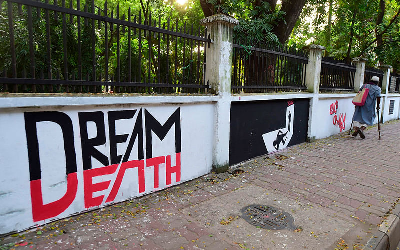 A Bangladeshi man walks past graffitis paint by students of Bangladesh University of Engineering and Technology (BUET) in the BUET campus in Dhaka on 16 October 2019 after a student named Abrar Fahad was allegedly beaten to death by ruling party activists