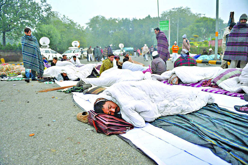 দিল্লির মুখ্যমন্ত্রী ও আম আদমি পার্টির নেতা অরবিন্দ কেজরিওয়ালসহ তাঁর দলের প্রায় ২০০ সমর্থক গত সোমবার রাজপথে রাত কাটান। গতকাল সকালে তোলা ছবি  এএফপি