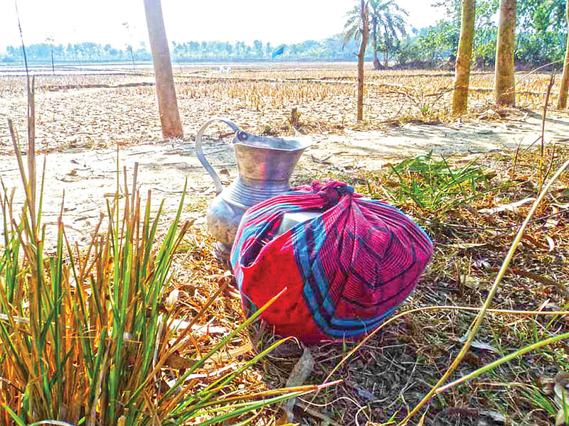 নজরুল ইসলামের জন্য খাবার নিয়ে গিয়েছিলেন তাঁর স্ত্রী। সে খাবার আর খাওয়া হয়নি নজরুলের। খাবার পড়ে আছে খেতের পাশে। দিনাজপুরের চাপড়া সীমান্তে বিএসএফের গুলিতে নিহত নজরুল l ছবি: প্রথম আলো