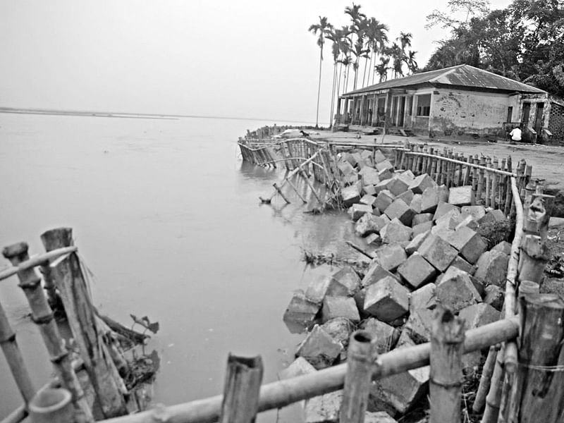 রংপুরের গঙ্গাচড়া উপজেলার আলমবিদিতর ইউনিয়নের পাইকান জুম্মাপাড়া সরকারি প্রাথমিক বিদ্যালয় তিস্তা নদীর ভাঙনের কবলে পড়েছে। সেই ভাঙন থেকে রক্ষা পেতে বাঁশের বেড়া দিয়ে বোল্ডার ফেলা হয়েছে। তবুও রক্ষা হচ্ছে না। গতকাল তোলা ছবি l প্রথম আলো