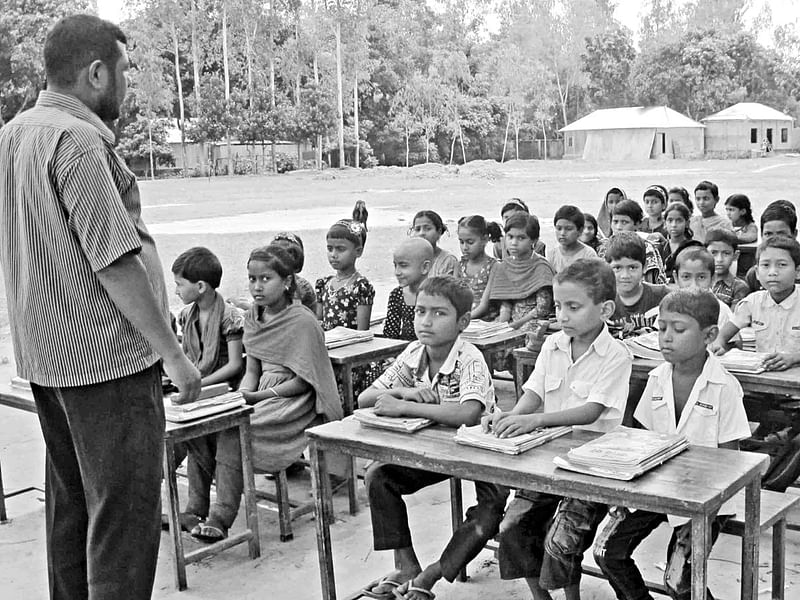 হাতেম হাসিল সরকারি প্রাথমিক বিদ্যালয়ের পড়াশোনা চলছে গাছতলায়। ছবিটি গত সোমবার তোলা l প্রথম আলো