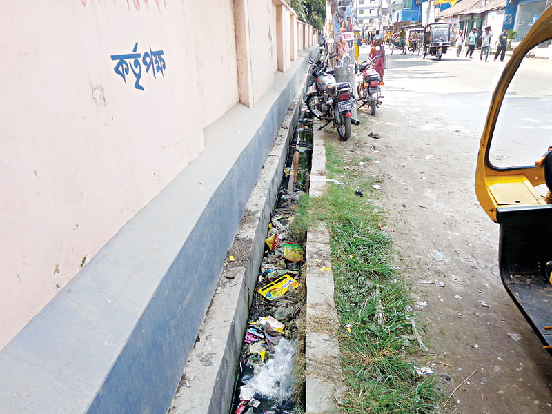 এভাবেই ময়লা–আবর্জনায় ভরে গেছে নর্দমা। গতকাল গাইবান্ধা শহরের ডিবি রোডের সরকারি মহিলা কলেজের সামনে থেকে তোলা ছবি l প্রথম আলো