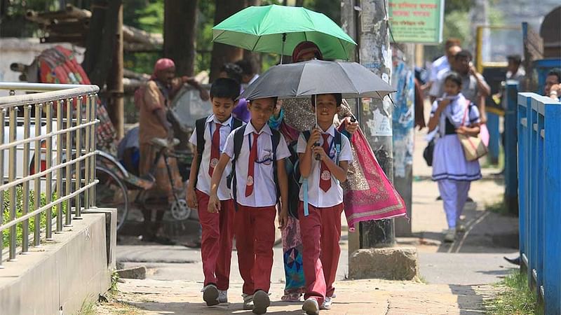 প্রচণ্ড গরমে ছাতা মাথায় স্কুল থেকে বাড়ি ফিরছে শিশুরা। ছবিটি তেজগাঁও শিল্প এলাকা থেকে মঙ্গলবার দুপুরে তোলা। ছবি: আশরাফুল আলম