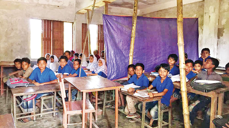 বাউফলের উত্তর-পূর্ব মদনপুরা সরকারি প্রাথমিক বিদ্যালয় ভবনে কাঠের তক্তা ও বাঁশ দিয়ে ঠেকনা দেওয়া হয়েছে। সম্প্র​তি ছবিটি তুলেছেন এ বি এম মিজানুর রহমান