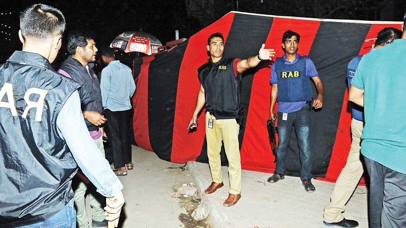 রাজধানীতে হজরত শাহজালাল আন্তর্জাতিক বিমানবন্দর গোলচত্বর এলাকায় পুলিশের তল্লাশিচৌকির কাছে গতকাল রাতে বোমা বিস্ফোরণে এক ব্যক্তি নিহত হন। ঘটনাস্থলের চারপাশ কাপড় দিয়ে ঢেকে রাখে আইনশৃঙ্খলা রক্ষাকারী বাহিনী l ছবি: প্রথম আলো