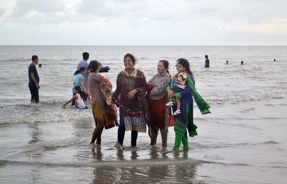 সৈকতে ফুরফুরে মেজাজে ঘুরছেন পর্যটকেরা। ছবি: শংকর দাশ