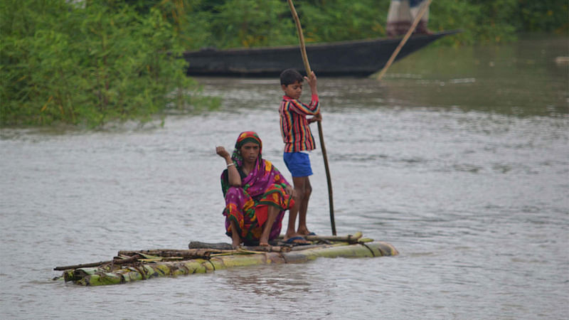 কুড়িগ্রামে বন্যার পানিতে সড়ক ডুবে যাওয়ায় কলাগাছের ভেলায় করে যাতায়াত করছেন দুর্গতরা। ছবি: সফি খান