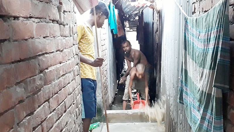 নবাবেরবাগ মধ্যপাড়া এলাকার একটি বাড়িতে জমে থাকা পানি সেচে ফেলা হচ্ছে। ছবিটি গতকাল দুপুরে তোলা l প্রথম আলো
