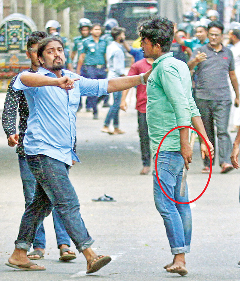 চট্টগ্রামের হাজী মুহাম্মদ মহসিন কলেজে গতকাল দুপুরে ছাত্রলীগের দুপক্ষের সংঘর্ষের সময় ধারালো অস্ত্র হাতে এক যুবক l ছবি: প্রথম আলো