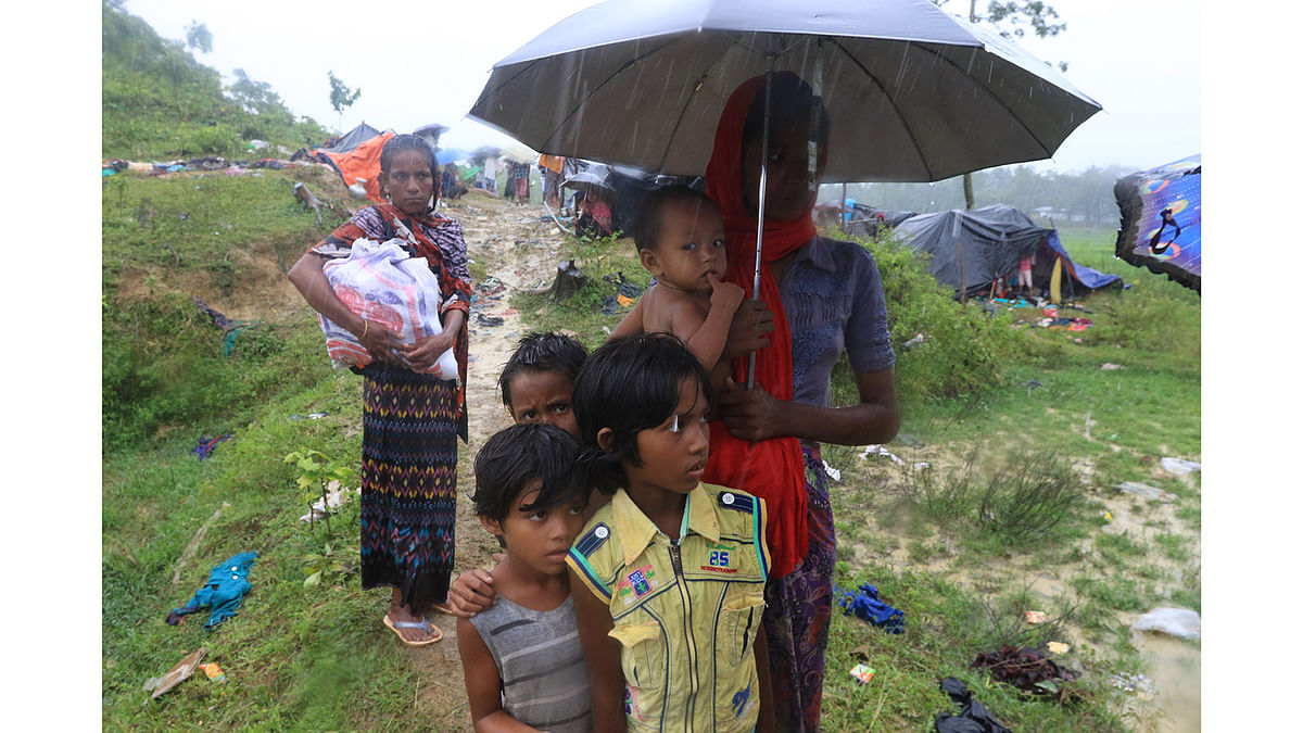 রোববারের বৃষ্টি বাংলাদেশে নতুন করে আশ্রয় নেওয়া রোহিঙ্গাদের দুর্ভোগ বাড়িয়ে দিয়েছে। সড়কে দাঁড়িয়ে ভিজতে হয়েছে অনেককে। ছবিটি রোববার উখিয়া উপজেলার থ্যাংখালী এলাকা থেকে তোলা। ছবি: আশরাফুল আলম