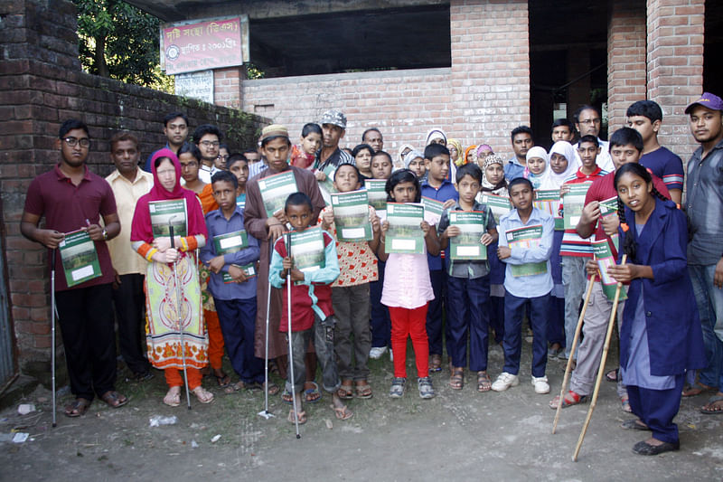 রংপুর নগরের জি এল রায় রোডে দৃষ্টি ও বুদ্ধিপ্রতিবন্ধী বিদ্যালয়ের শিক্ষার্থীদের মাঝে সাদাছড়ি ও শিক্ষা উপকরণ বিতরণ করেন রংপুর বন্ধুসভার সদস্যরা। ছবি: মঈনুল ইসলাম