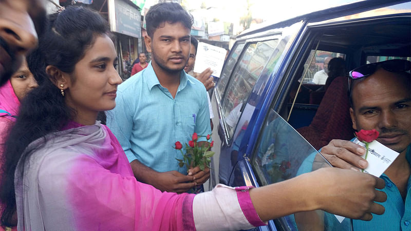 বদরগঞ্জ-রংপুর সড়কে চলাচল করা শতাধিক যানবাহনের চালকের হাতে গোলাপ ফুল ও নিরাপদে যান চালানোর জন্য সচেতনতামূলক কার্ড তুলে দিচ্ছেন বদরগঞ্জ বন্ধুসভার সদস্যরা। ছবি: আলতাফ হোসেন