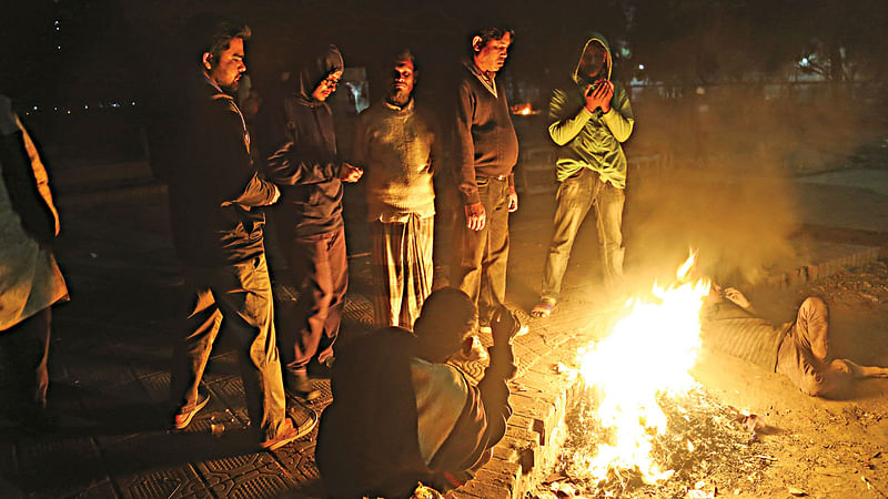 রমনা পার্কের ভেতর শুকনা পাতায় আগুন জ্বালিয়ে শীত তাড়ানোর চেষ্টা