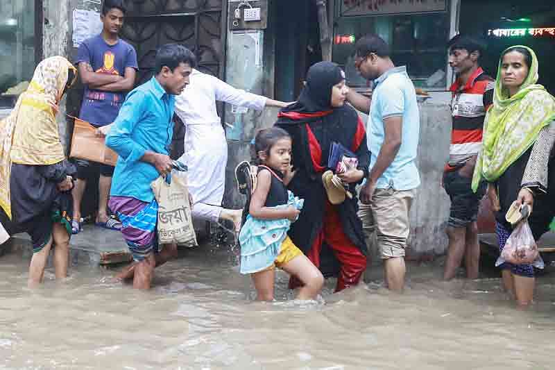 টানা দুই দিনের বৃষ্টিতে রাজধানীর বিভিন্ন স্থানে সৃষ্টি হয় জলাবদ্ধতা। ভোগান্তিতে পড়ে পথচারীরা। গতকাল ঢাকার পূর্ব জুরাইনের হাজী কে আলী রোডে হাঁটুপানিতে গর্ত দেখে দেখে চলছে এলাকাবাসী।  ছবি: প্রথম আলো