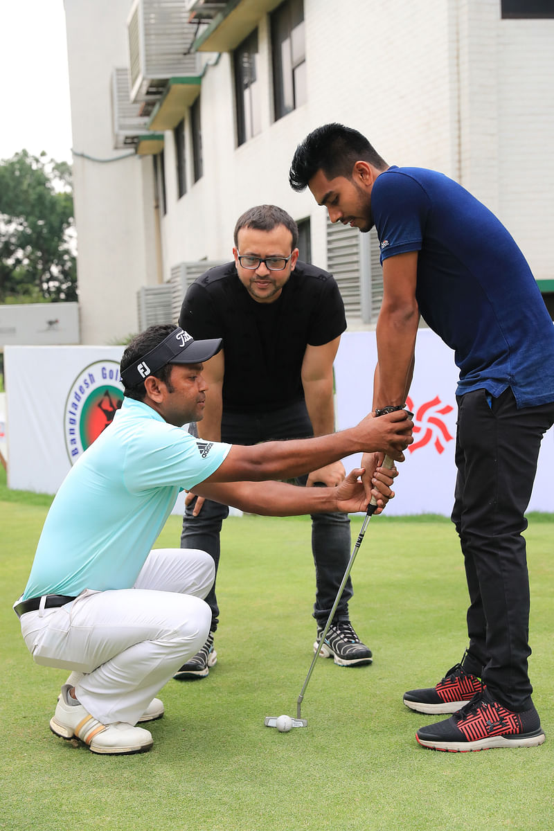 কুর্মিটোলা গলফ কোর্সে ক্লাব (গলফ স্টিক) হাতে মিরাজ। তাঁকে শেখাচ্ছেন গলফার সিদ্দিকুর। আর পেছন থেকে দেখছেন রিয়াজ। ছবি প্রথম আলো