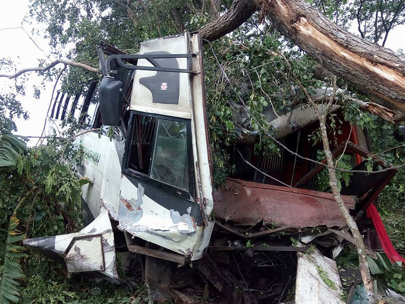 বাসটি সড়কের পাশে গাছের সঙ্গে ধাক্কা খেয়ে গাছসহ সড়কের পাশে খাদে পড়ে যায়। ছবি: প্রথম আলো