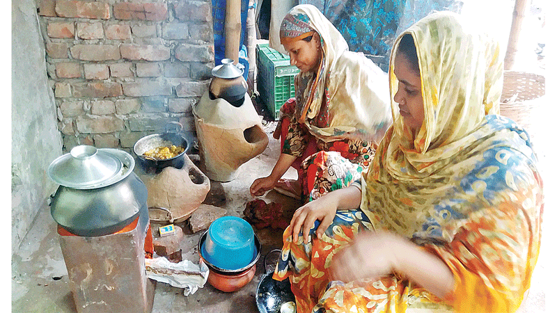 গ্যাস–সংকটের কারণে মাটির চুলায় রান্না করছেন মিরপুর–১১ নম্বরের দুই বাসিন্দা।