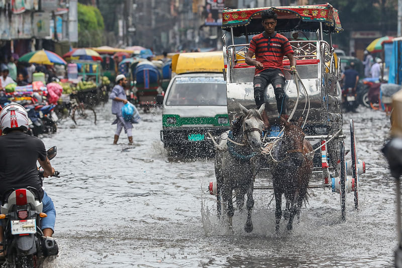 অল্প সময়ের জন্য হলেও ভারী বৃষ্টিতে পুরান ঢাকার অনেক এলাকাতেই জলাবদ্ধতার সৃষ্টি হয়। বঙ্গবাজার এলাকার সড়কে পানি জমে ভোগান্তিতে চলাচলকারীরা। ঢাকা, ১১ সেপ্টেম্বর। ছবি: দীপু মালাকার