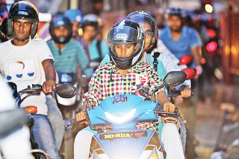 রাজধানীতে অ্যাপভিত্তিক মোটরসাইকেল চালাচ্ছেন নারী। গত বুধবার কাজী নজরুল ইসলাম অ্যাভিনিউতে।  প্রথম আলো