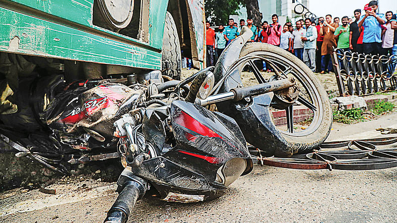 দ্রুতগামী বাস নিয়ন্ত্রণ হারিয়ে রাজধানীর জাহাঙ্গীর গেটে মোটরসাইকেলচালকের ওপর উঠে যায়। বাসের নিচে পিষ্ট হয় মোটরসাইকেল। আহত চালক আনোয়ার হোসেনকে হাসপাতালে নেওয়ার পর মারা যান। গতকাল দুপুরে ঘটনাস্থলে।  ছবি: সাজিদ হোসেন