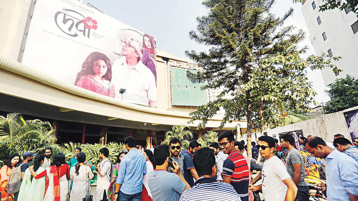 গতকাল দুপুরে রাজধানীর বলাকা সিনেমা হলের বাইরে দেবী দেখার অপেক্ষায় দর্শকেরা।  ছবি: সুমন ইউসুফ