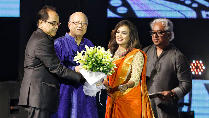 ঢাকা ইন্টারন্যাশনাল ফোক ফেস্ট-২০১৮–এর উদ্বোধনী দিনে প্রধান অতিথি অর্থমন্ত্রী আবুল মাল আবদুল মুহিতকে ফুল দিয়ে শুভেচ্ছা জানান সান কমিউনিকেশনস লিমিটেডের চেয়ারম্যান অঞ্জন চৌধুরী