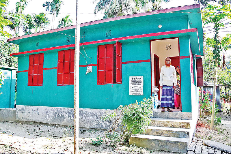 অসচ্ছল মুক্তিযোদ্ধাদের জন্য সরকারের দেওয়া লাল-সবুজ রঙের বাড়ি ‘বীর নিবাস’। সম্প্রতি ফরিদপুরের বোয়ালমারী উপজেলার শুকদেব নগর গ্রামে।  ছবি: প্রথম আলো