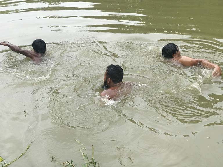 সাঁতার কাটছেন তিন প্রতিবন্ধী সাঁতারু। ছবি: প্রথম আলো