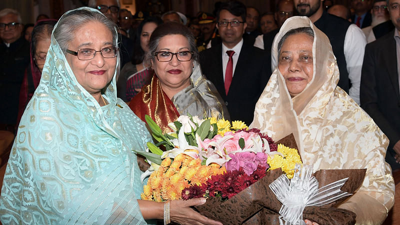 রাষ্ট্রপতি আবদুল হামিদের স্ত্রী রাশিদা খানম নবনিযুক্ত প্রধানমন্ত্রী শেখ হাসিনাকে বঙ্গভবনে ফুল দিয়ে শুভেচ্ছা জানান। এ সময় প্রধানমন্ত্রীর ছোট বোন শেখ রেহানা তাঁর সঙ্গে ছিলেন। ঢাকা, ৭ জানুয়ারি। ছবি: পিআইডি