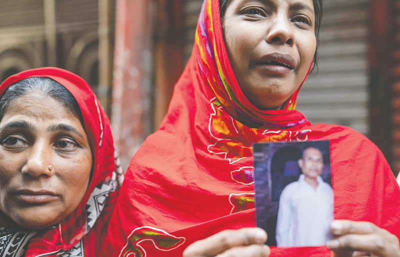 পুরান ঢাকার চকবাজারের অগ্নিকাণ্ডের পরের দিন, নাসরিন ছবি হাতে খুঁজে ফিরছেন হারিয়ে যাওয়া বাবাকে। ২১ ফেব্রুয়ারি ২০১৯। ছবি: আবীর আবদুল্লাহ