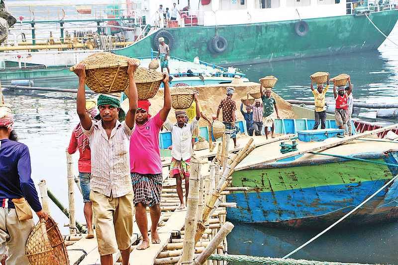 বালু এনে রাখা হচ্ছে নদীর পাড়ে। বুধবার নারায়ণগঞ্জের শিমরাইল এলাকায়।  প্রথম আলো