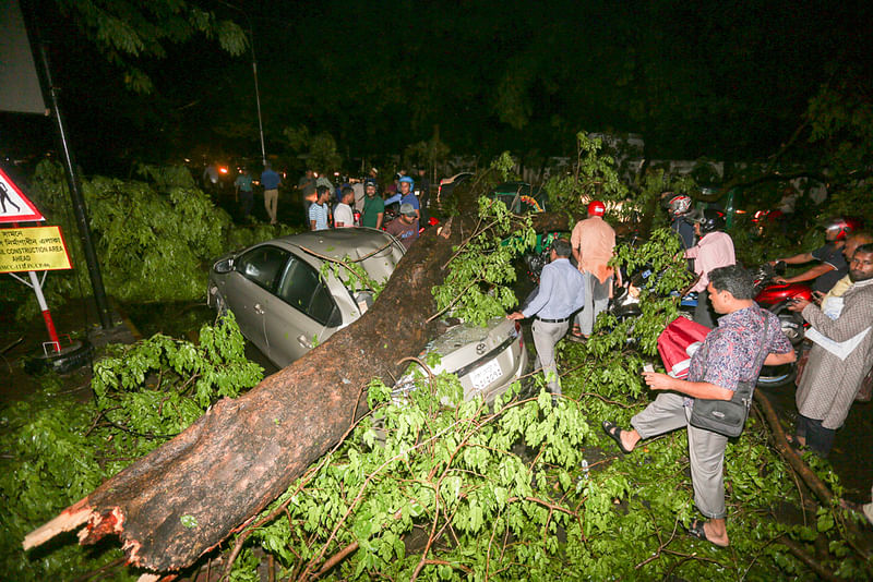 ঝড়ে রাজধানীর বিভিন্ন সড়কে গাছের ডাল, বিদ্যুতের খুঁটি ভেঙে পড়েছে। নগরীর হেয়ার রোড এলাকায় চলন্ত গাড়ির ওপর গাছের ডাল ভেঙে পড়ে। এতে গুরুতর আহত হন বেশ কয়েকজন। হেয়ার রোড, ঢাকা, ৩১ মার্চ। ছবি: হাসান রাজা