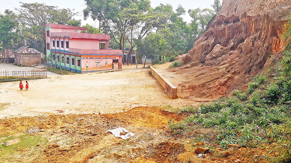 মাদ্রাসা স্থাপনের জন্য ঝুঁকিপূর্ণ এই টিলার পাদদেশ ছেঁটে ফেলা হচ্ছে। ৩১ মার্চ সকালে জুড়ী উপজেলার মনতৈল গ্রামে।  ছবি: প্রথম আলো