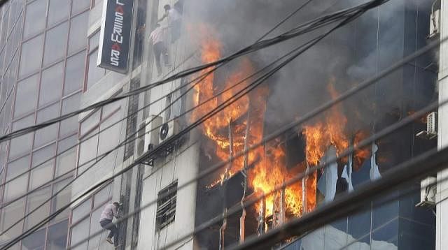 আগুনে জ্বলছে এফ আর টাওয়ার। ভবন বেয়ে নিচে নামছেন কয়েকজন। বনানী, ঢাকা, ২৮ মার্চ। ছবি: প্রথম আলো