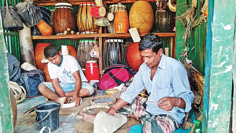 ঢোল তৈরিতে ব্যস্ত পিতা–পুত্র। গত বৃহস্পতিবার গাজীপুর সদরের দরগারচালা এলাকায়।