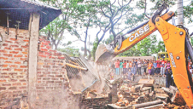 নালার ওপর বেকারি পণ্যের কারখানা উচ্ছেদ করছে সিটি করপোরেশন। গতকাল সিলেট নগরের ২৭ নম্বর ওয়ার্ডের শিববাড়িতে।  প্রথম আলো